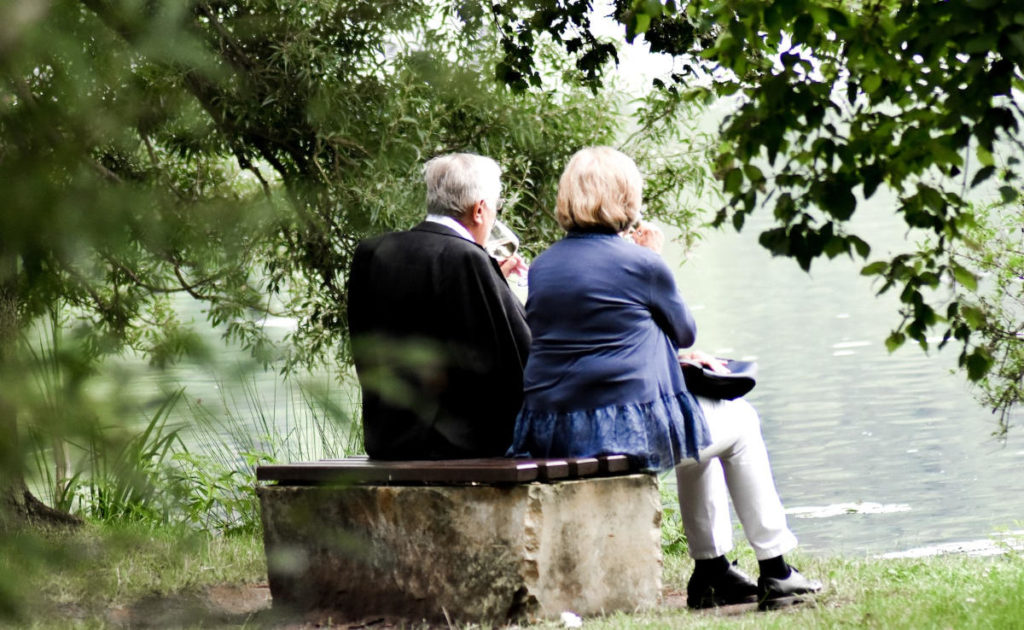 older couple sitting by a lake